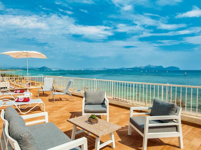 Terrasse avec meubles et vue sur la mer sous un ciel dégagé