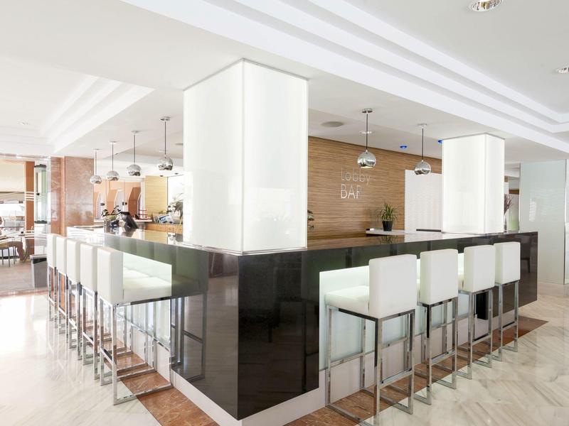 Modernes Hotelbuffet mit weißen Barhockern und elegantem Ambiente.