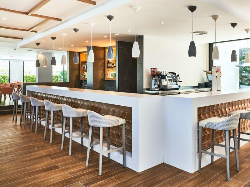 Modern hotel bar area with white chairs and wooden floor