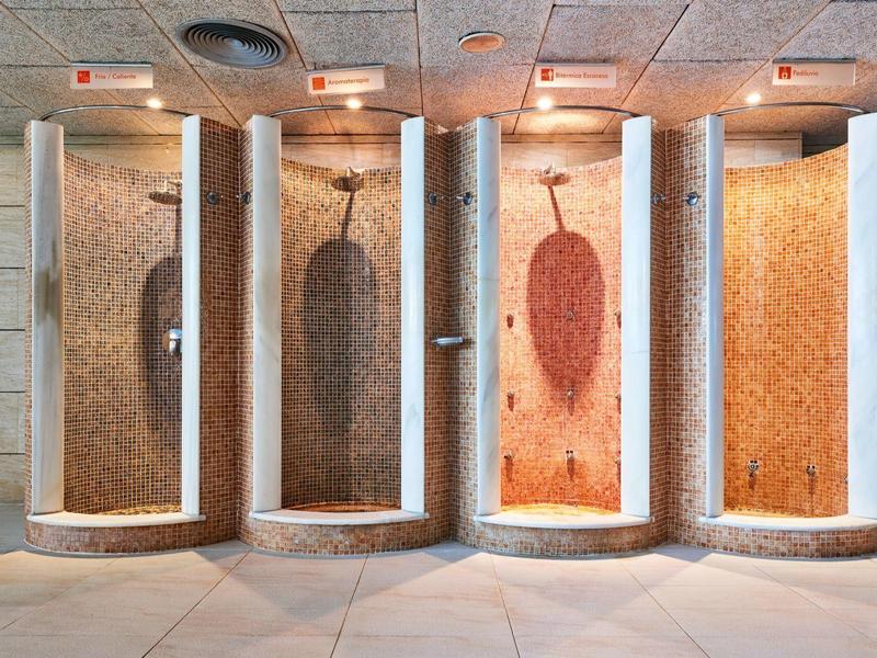 Four different colored steam showers in a modern spa facility.