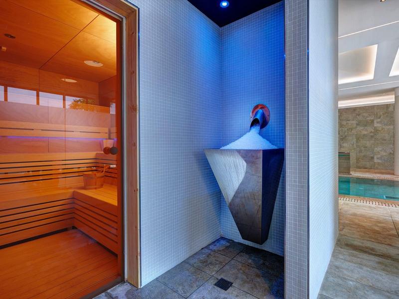 Área de bienestar moderna con sauna y piscina en un elegante hotel spa.