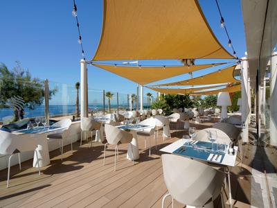 Terraza de restaurante en la playa con toldos amarillos y vista al mar