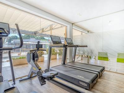 Palestra luminosa con tapis roulant e vista su un lago attraverso grandi finestre