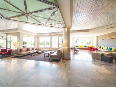 Bright hotel lobby with modern seating areas and large windows for plenty of natural light.