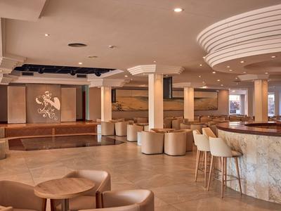 Innenbereich einer modernen Hotellounge mit Sitzgelegenheiten und Bar.