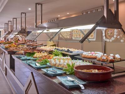 Buffet mit einer Vielfalt an Speisen in einem Hotelrestaurant, präsentiert in warmen Tönen.