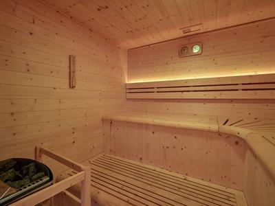Innensauna mit Holzbänken, Holzwänden und dimmbarer Beleuchtung für Entspannung.