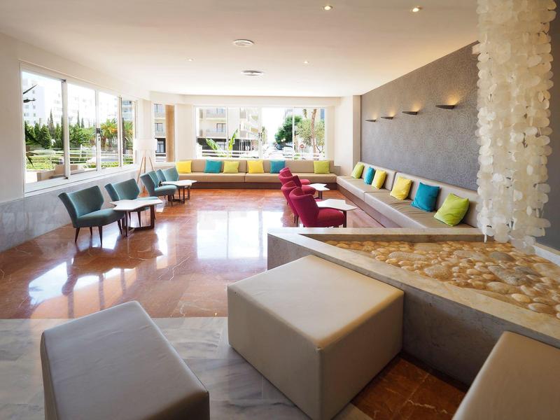 Lounge dell'hotel luminosa e moderna con aree salotto confortevoli e grandi finestre.