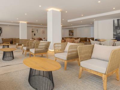 Moderní hotelový salonek s minimalistickým dřevěným nábytkem a neutrálními barvami