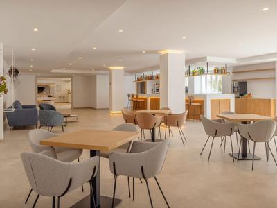 Ristorante luminoso e moderno con sedie comode e tavoli in legno in un hotel.