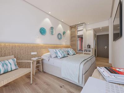 Camera da letto moderna con letto grande, sedia in legno e pareti decorative in toni chiari.