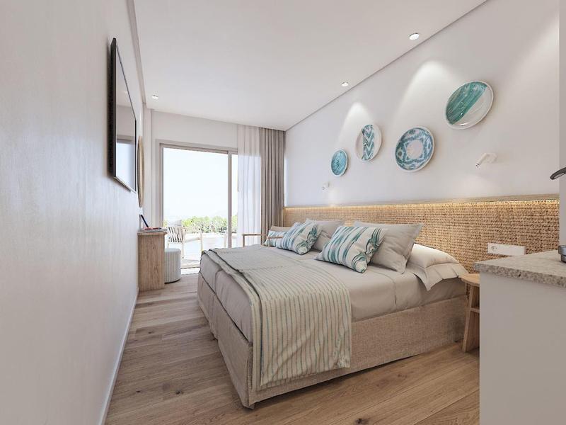 Camera d'hotel moderna con letto matrimoniale, pavimento in legno, piatti decorativi a parete e vista sul balcone.