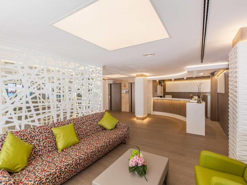 Modern hotel lobby with colorful cushions, stylish seating, and bright ambiance.