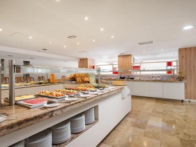 Buffet de hotel luminoso con variedad de alimentos y elementos modernos de madera y mármol.