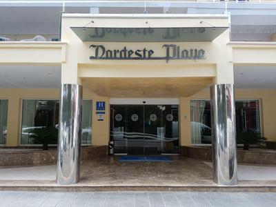 Entrada del hotel Dorchester Plaza con columnas lisas y marquesina de vidrio.