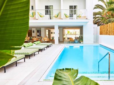 Modern outdoor pool with lounge chairs in a bright, stylish hotel setting