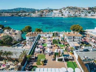 Strefa rekreacyjna z basenami i leżakami przed nadmorskim miastem z niebieskim morzem.