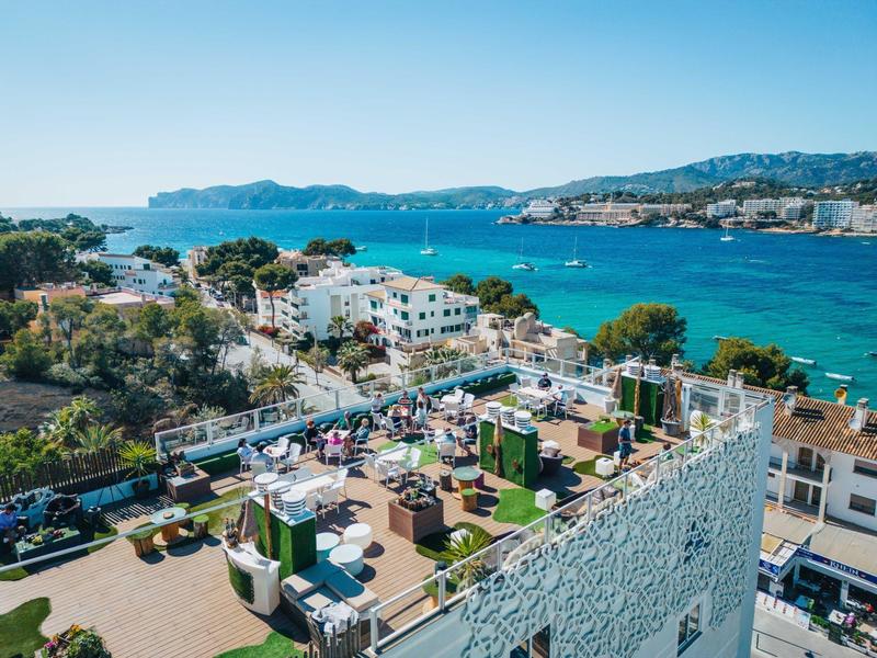 Taras na dachu z miejscami do siedzenia z widokiem na niebieskie morze i krajobraz miasta.