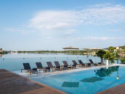Piscina con lettini a bordo lago sotto un cielo azzurro