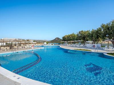 Gran piscina al aire libre con agua cristalina y vista de los alrededores bajo cielo despejado.