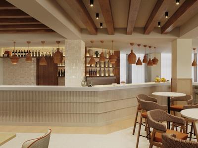 Modern hotel bar area with light wooden furniture and stylish pendant lights.