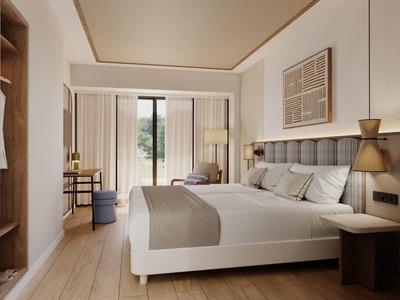 Modern hotel room with double bed, seating area, and balcony overlooking greenery.