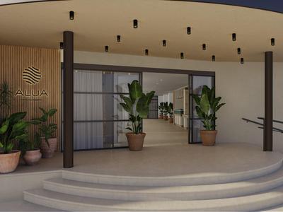 Modern hotel entrance with plants and wide stairs under a covered area.