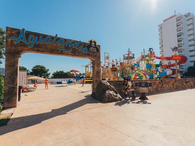 Barevný aquapark s tobogány a velkým vstupním nápisem pod jasnou oblohou.