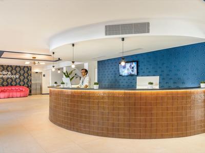 Moderner Hotellobby mit geschwungenem Empfangstresen, blauem Akzent und Empfangspersonal.