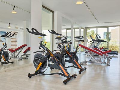 Moderner Fitnessraum mit Trainingsrädern und Hanteln in einem hellen, geräumigen Raum.