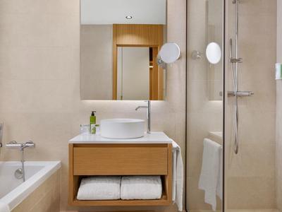 Bagno moderno con lavabo, vasca, doccia e specchio.