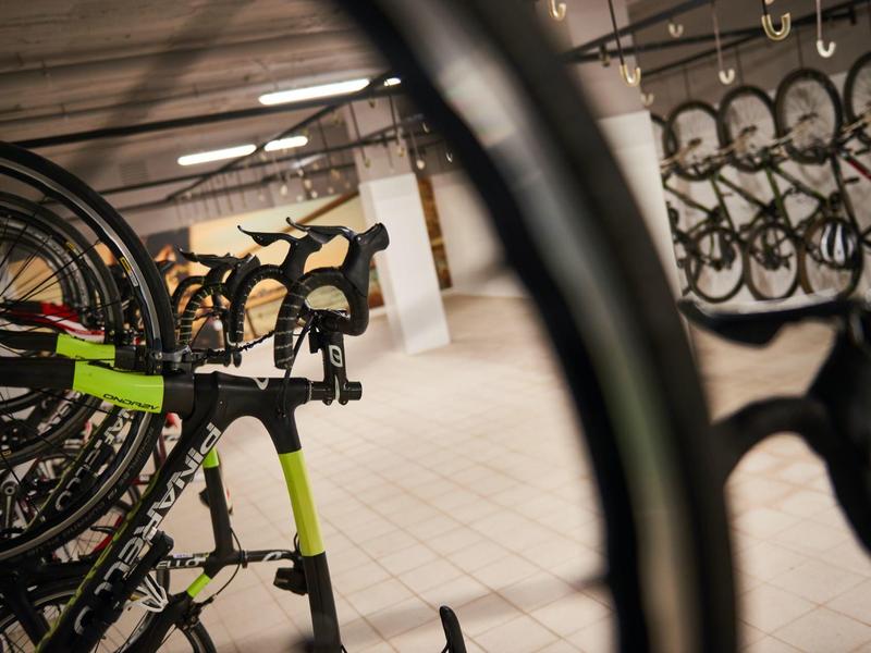 Fila di biciclette allineate in uno spazio interno illuminato.