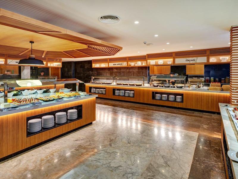 Buffet di ristorante moderno con banconi in legno e illuminazione calda.