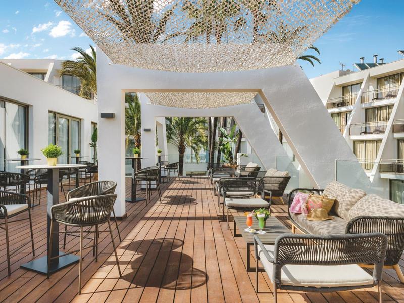 Accogliente terrazza con pavimento in legno, arredi lounge e piante in un hotel