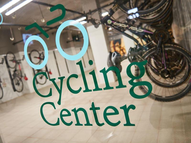 Centro ciclismo con diverse biciclette parcheggiate lungo una parete interna.