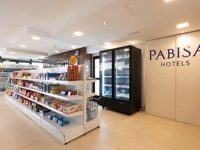 Moderní hotelový obchod s regály plnými svačin a chlazených nápojů v Pabisa Hotels.