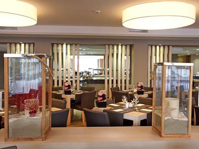 Ristorante moderno con tavoli apparecchiati e lampade eleganti al soffitto.