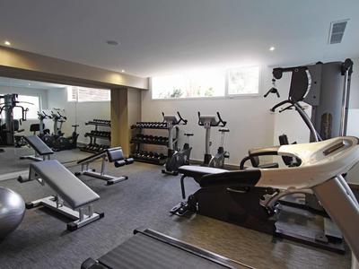 Palestra moderna con tapis roulant, pesi e attrezzi per l'allenamento.