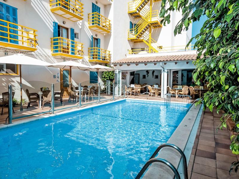 Moderne buitenzwembad in hotel met gele relingen en overdekte zitruimte