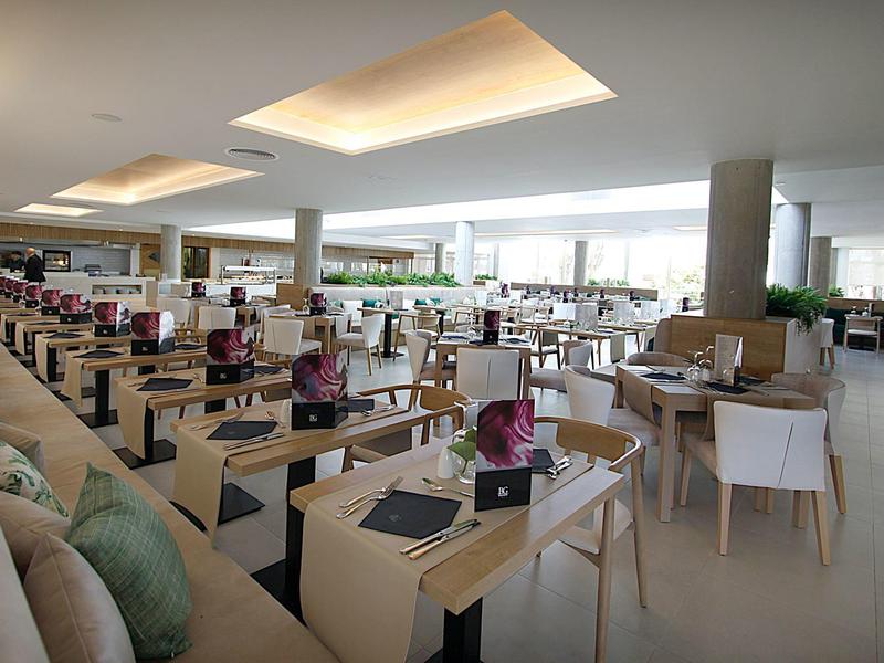 Großer, heller Speisesaal mit vielen Tischen, weißen Stühlen und moderner Beleuchtung.