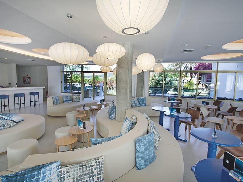 Heller, moderner Lounge-Bereich mit runden Sofas, Tischen und großen Papierlampen im Hotel.