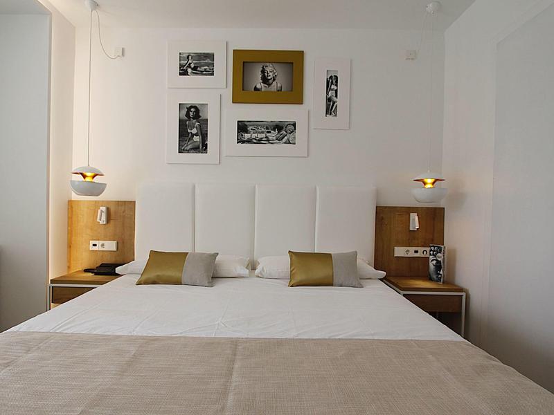 Gemütliches Hotelzimmer mit großem Bett, weißen Wänden und moderner Wanddekoration.