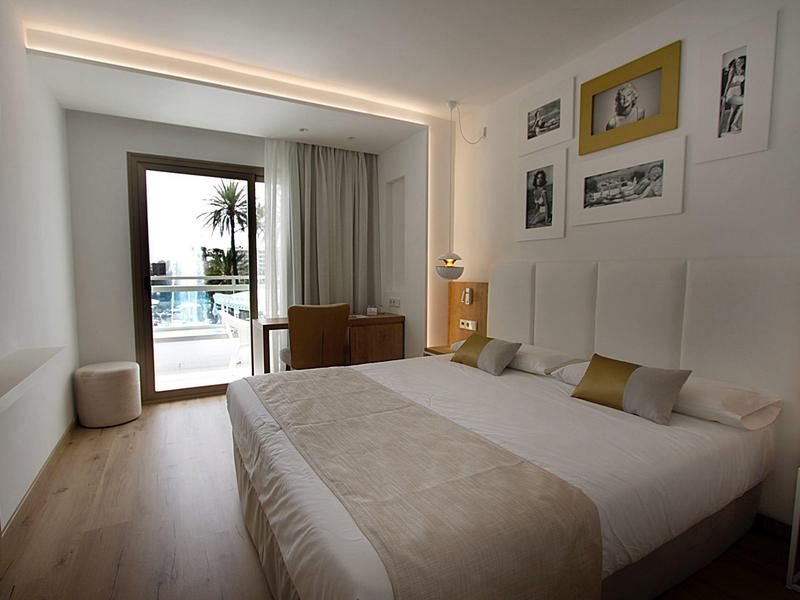 Modernes Hotelzimmer mit Doppelbett, Holzboden und Zugang zu Terrasse mit Meerblick