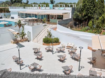 Freier Außenbereich eines Hotels mit Tischen, Stühlen, Pool und moderner Architektur