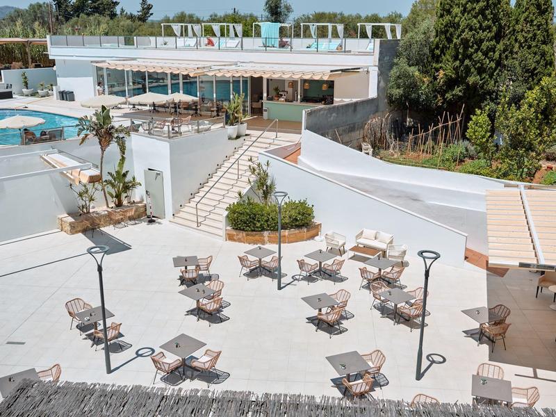 Freier Außenbereich eines Hotels mit Tischen, Stühlen, Pool und moderner Architektur