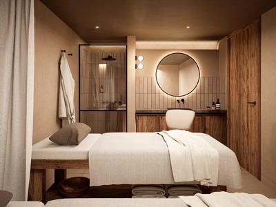 Gemütlicher Massageraum mit Behandlungsbank, rundem Spiegel, warmen Holzakzenten und sanfter Beleuchtung.