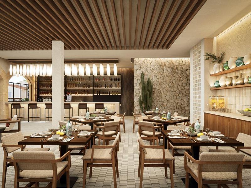 Modern gestaltetes Restaurant mit Holzmöbeln, hellem Interieur und dekorativen Pflanzen an der Wand.