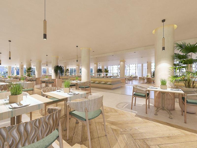 Restaurante luminoso y moderno con suelos de madera, plantas verdes y mobiliario minimalista.