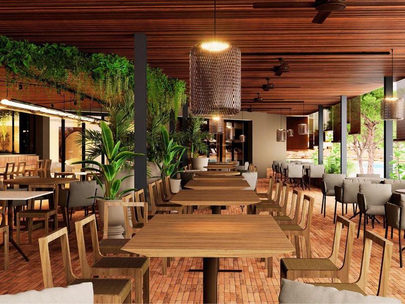 Amplio comedor moderno de hotel con mesas de madera, sillas y muchas plantas verdes.