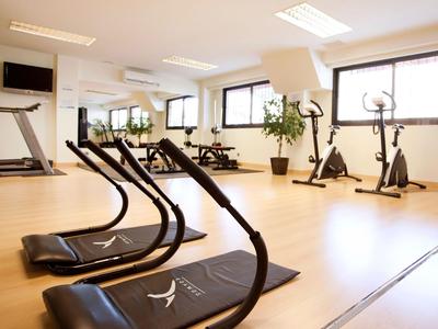 Lichte fitnessruimte met loopbanden, hometrainers en grote ramen